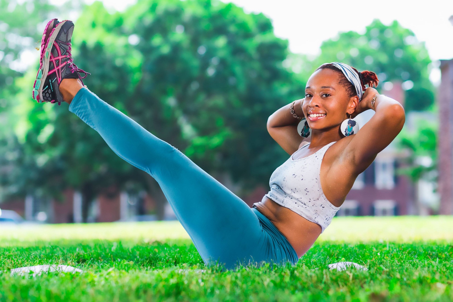 Clarissa Shepherd performing a seated core hold outdoors on the grass